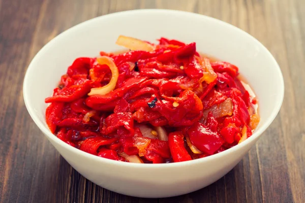 Poivron rouge grillé avec salade d'oignons sur bol blanc — Photo