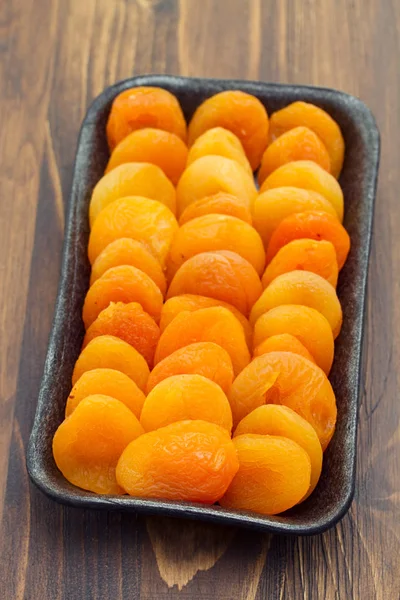 Abricot sec sur plat plastique noir — Photo