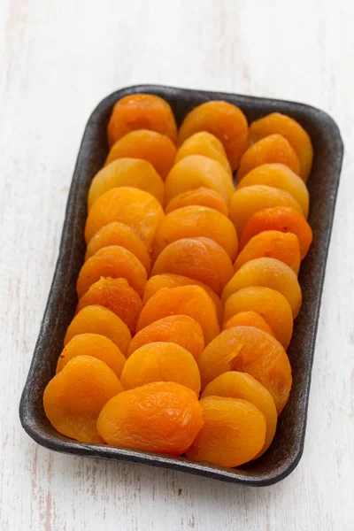 Dry apricot on black plastic dish — Stock Photo, Image