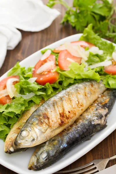 Grilled sardines with salad on white dish — Stock Photo, Image