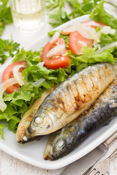 Sardinhas grelhadas com salada em prato branco — Fotografia de Stock