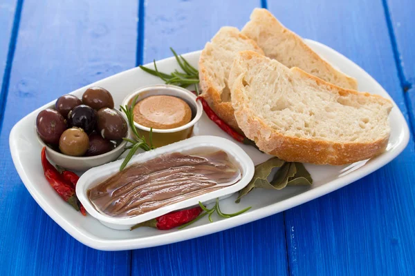 Anchois, olives, pain et pâte de poisson sur le plat — Photo