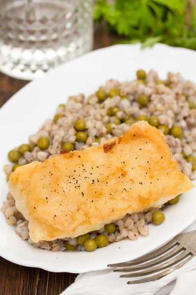 Gebratener Fisch mit gekochtem Buchweizen und Erbsen in weißer Schale — Stockfoto