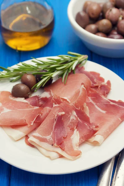 Jamon with olives on white plate — Stock Photo, Image