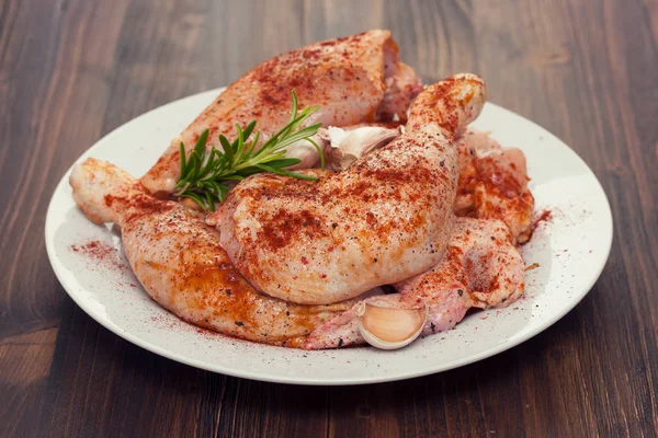 Rohes Huhn mit Pfeffer und Knoblauch auf weißem Teller — Stockfoto