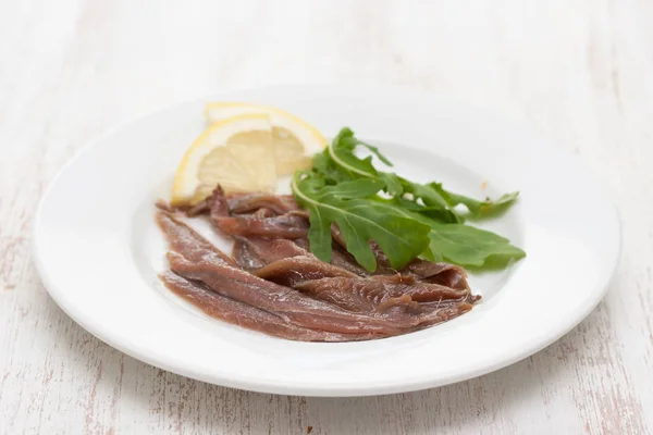 Anchovies with lemon on the white plate — Stock Photo, Image