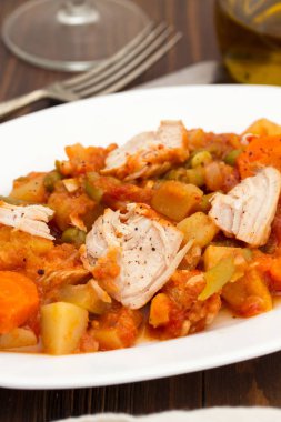 Türkiye güveç ahşap arka plan üzerinde beyaz tabak sebze ile