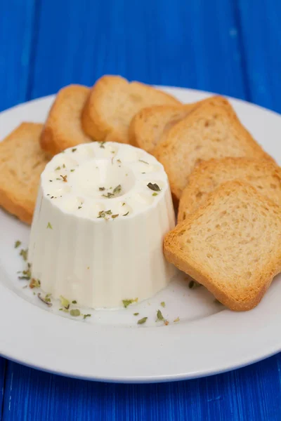 Fresh cheese with toasts on white plate — Stock Photo, Image