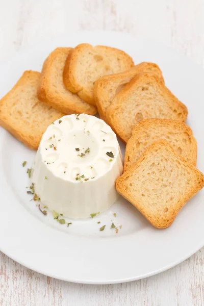 Formaggio fresco con pane tostato su piatto bianco — Foto Stock