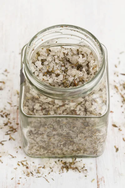Salz mit Kräutern im Glas auf Holzgrund — Stockfoto