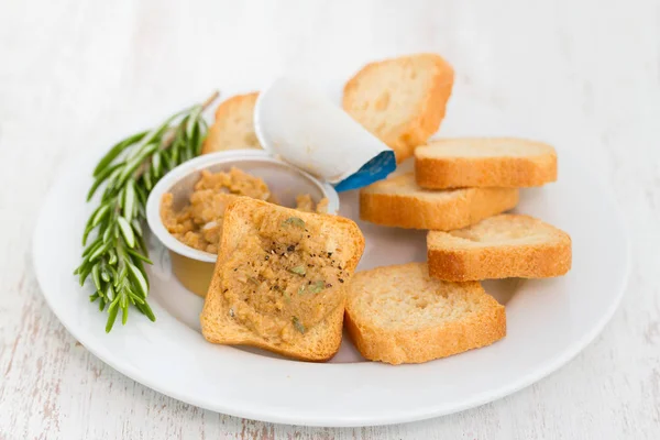 Rostat bröd med fiskpaté på vit tallrik — Stockfoto