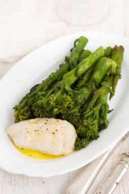 yeşil ve beyaz tabak üzerine zeytin yağı ile haşlanmış balık 