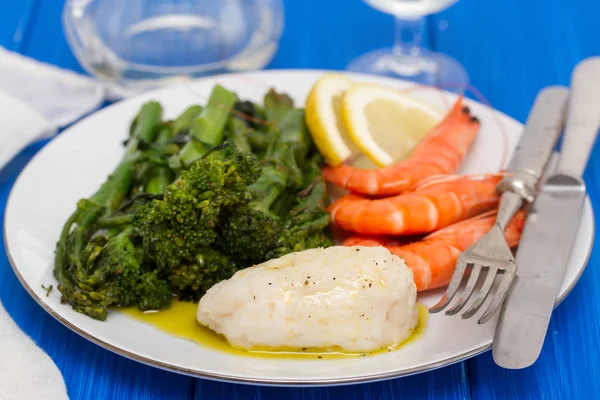 Pescado cocido con verduras y gambas en plato blanco — Foto de Stock