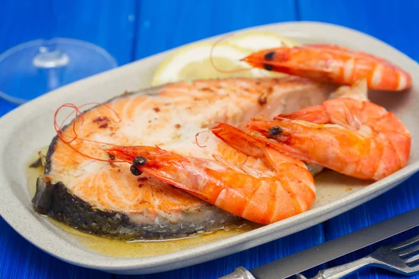 Fried salmon with shrimps on white dish on wooden background — Stock Photo, Image