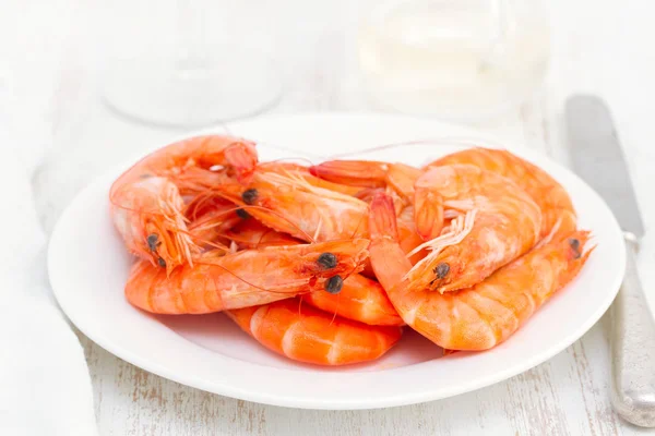 Boiled shrimps on white dish on wooden background — Stock Photo, Image