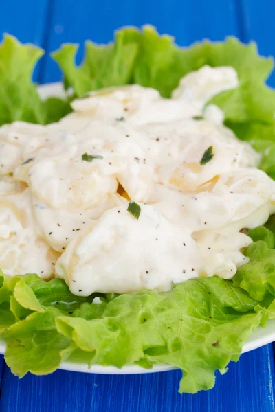 Potato salad on white plate on wooden background — Stock Photo, Image