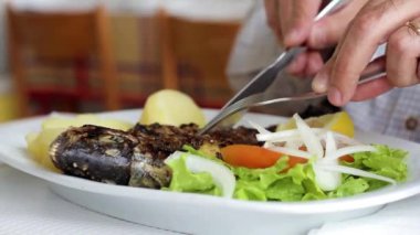 adam yeme balık haşlanmış patates ve taze salata ile beyaz çanak üzerinde