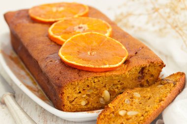 ahşap arka plan üzerinde beyaz çanak üzerinde turuncu kabak pasta