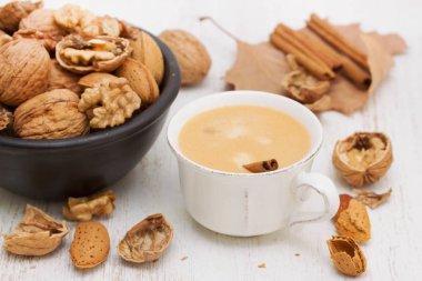 bir fincan kahve ve ahşap zemin üzerine fındık