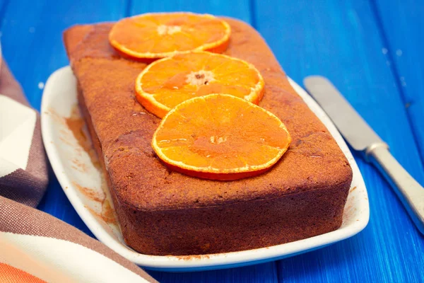 Dýňový koláč s pomerančem na bílé misce na dřevěné pozadí — Stock fotografie