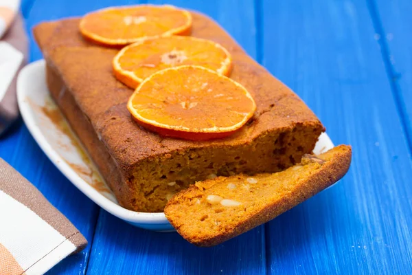 ahşap arka plan üzerinde beyaz çanak üzerinde turuncu kabak pasta