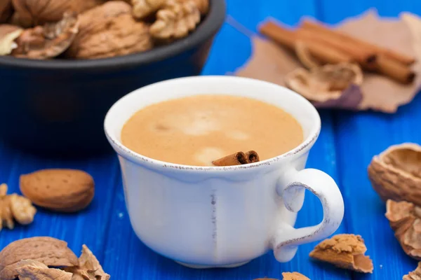 Eine Tasse Kaffee und Nüsse auf Holzuntergrund — Stockfoto