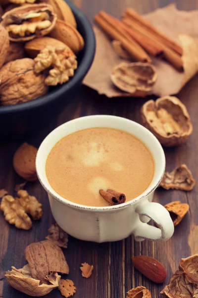 bir fincan kahve ve ahşap zemin üzerine fındık