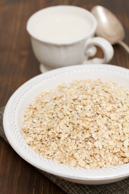Beyaz kase ve süt, bir fincan yulaf ezmesi