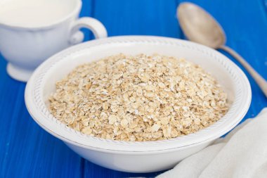 Beyaz kase ve süt, bir fincan yulaf ezmesi 