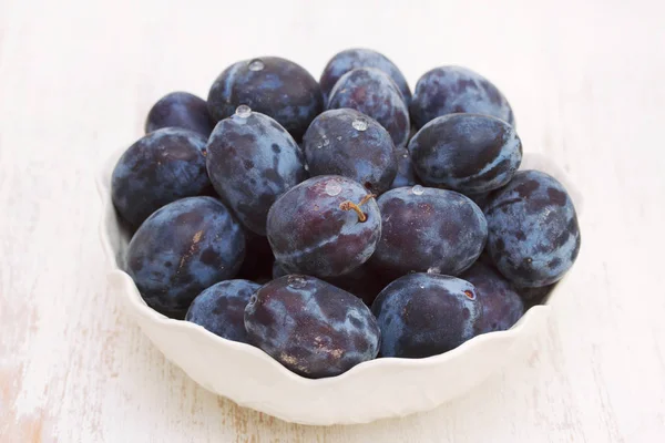 Fresh plums in white bowl — Stock Photo, Image