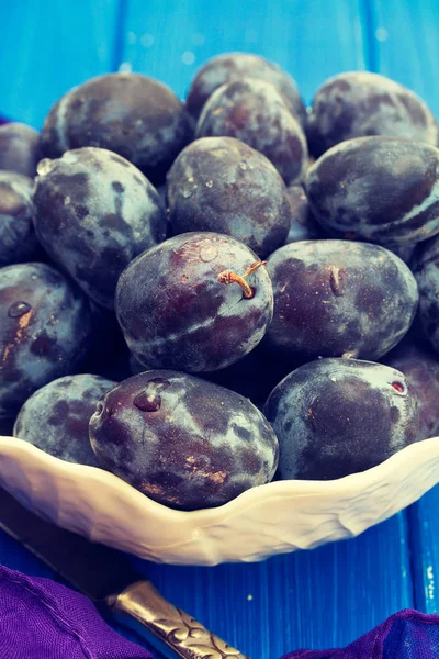 Fresh plums in white bowl — Stock Photo, Image