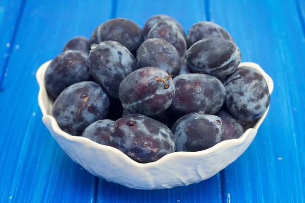 Fresh plums in white bowl — Stock Photo, Image