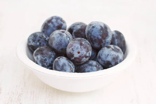 Fresh plums in white bowl — Stock Photo, Image