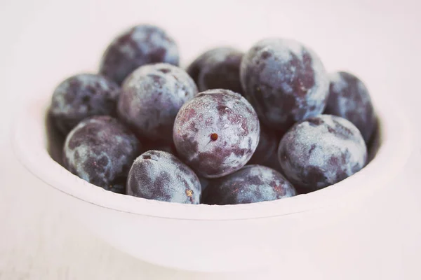 Fresh plums in white bowl — Stock Photo, Image