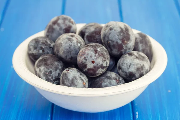 Fresh plums in white bowl — Stock Photo, Image