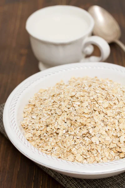 Beyaz kase ve süt, bir fincan yulaf ezmesi