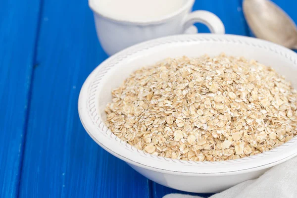 Beyaz kase ve süt, bir fincan yulaf ezmesi