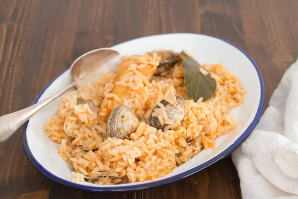 Rice with seafood and fish on dish on wooden background — Stock Photo, Image