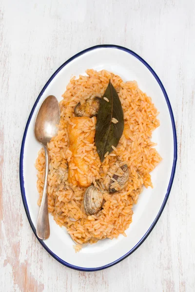 Рис з морепродуктами та рибою на тарілці на дерев'яному фоні — стокове фото