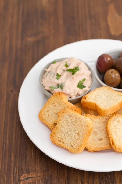 Toasts mit Fischpastete und Oliven auf weißem Teller — Stockfoto