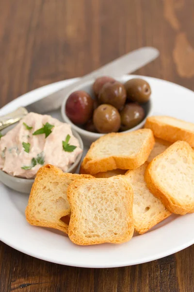 Toasts mit Fischpastete und Oliven auf weißem Teller — Stockfoto