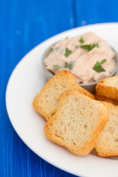Toasts mit Fischpastete und Oliven auf weißem Teller — Stockfoto