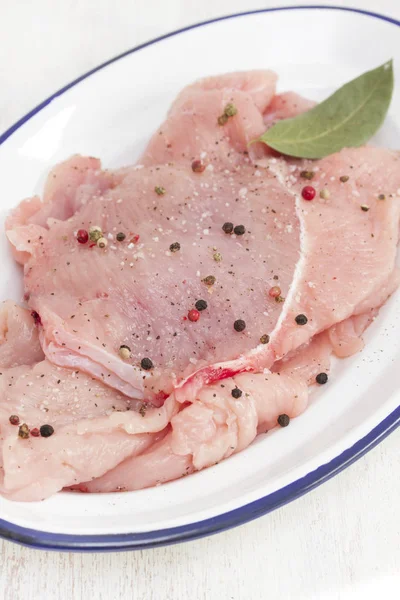 Raw turkey with pepper and bay leaf on white dish — Stock Photo, Image