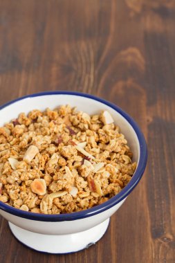 Granola ahşap arka plan üzerinde kase fındık