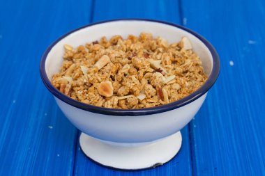 Granola ahşap arka plan üzerinde kase fındık