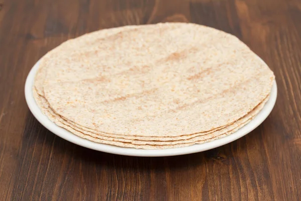 Pita on white plate on wooden background — Stock Photo, Image
