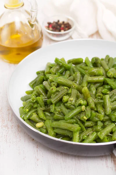 Green beans on frying pan on wooden background — Stock Photo, Image