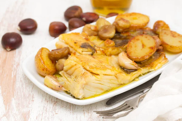 Bacalhau frito com castanhas e batata no prato branco — Fotografia de Stock