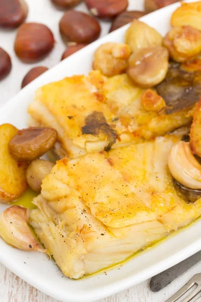 Bacalhau frito com castanhas e batata no prato branco — Fotografia de Stock