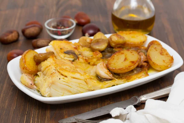 Bacalhau frito com castanhas e batata no prato branco — Fotografia de Stock